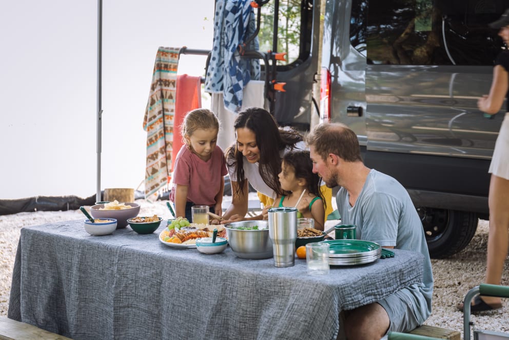 family eating at campground in class b rv