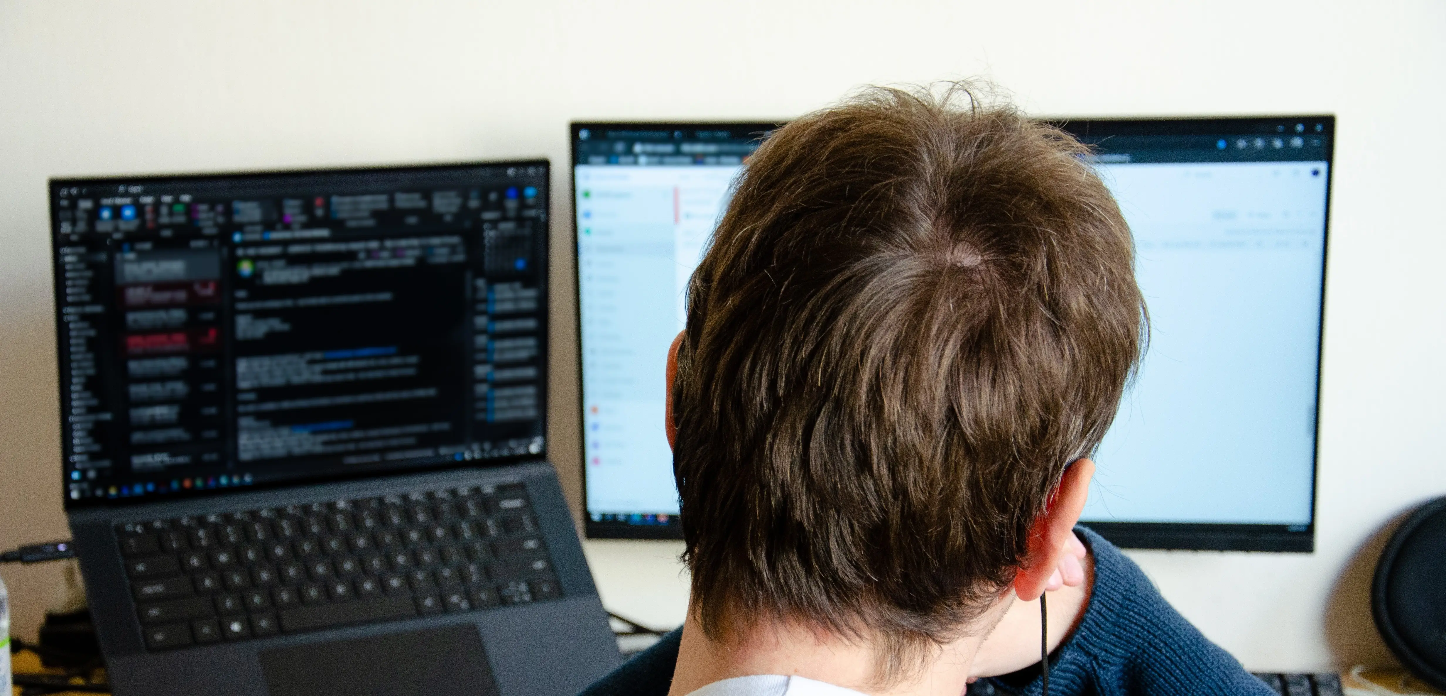 Independent contractor working on dual monitors in ergonomic home office setup