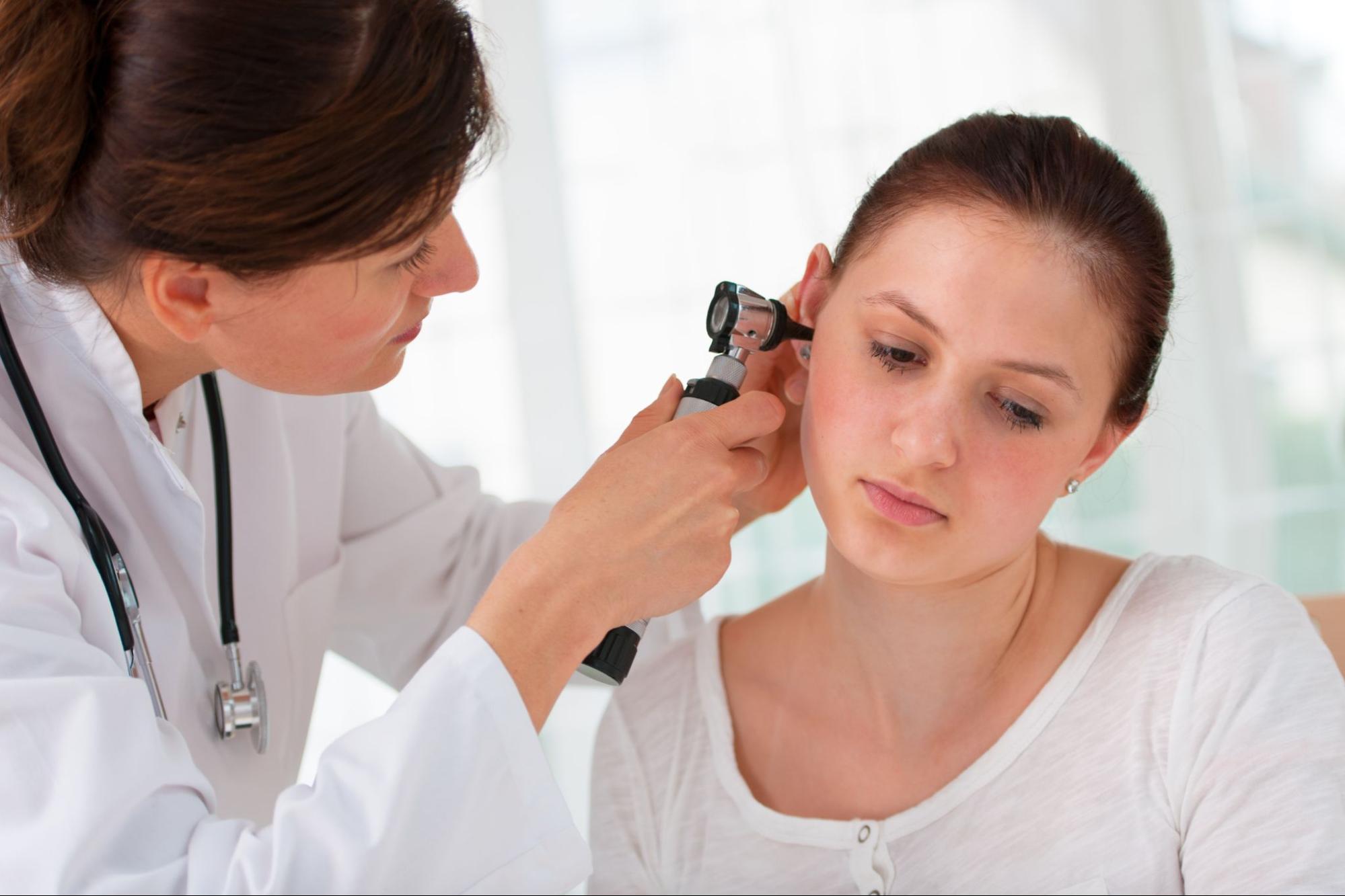 thumping in ear: doctor checking her patients ear
