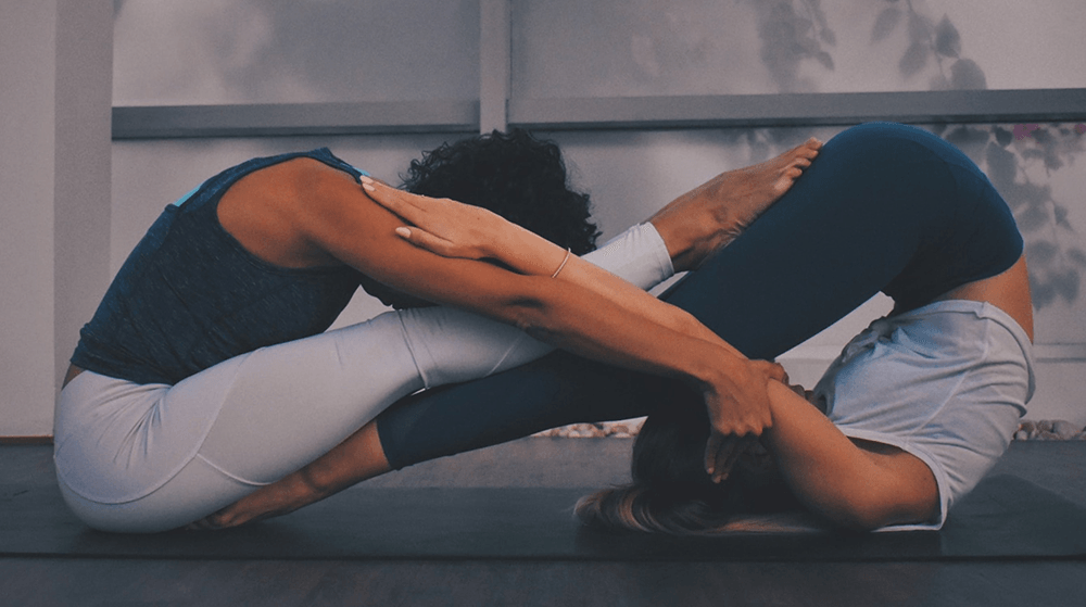 Two women practicing partner yoga