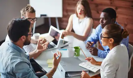 Five individuals having a work meeting