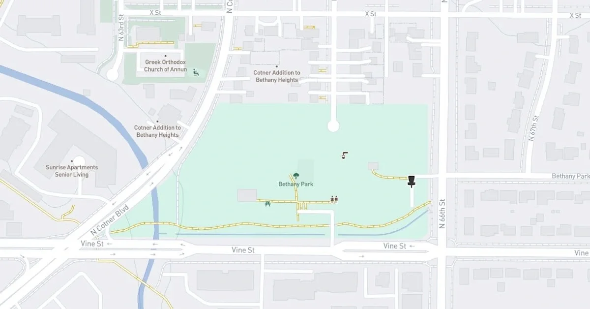 A navigation map with a green space indicating a park and a basket indicating a disc golf course surrounded by roads, businesses, and residences
