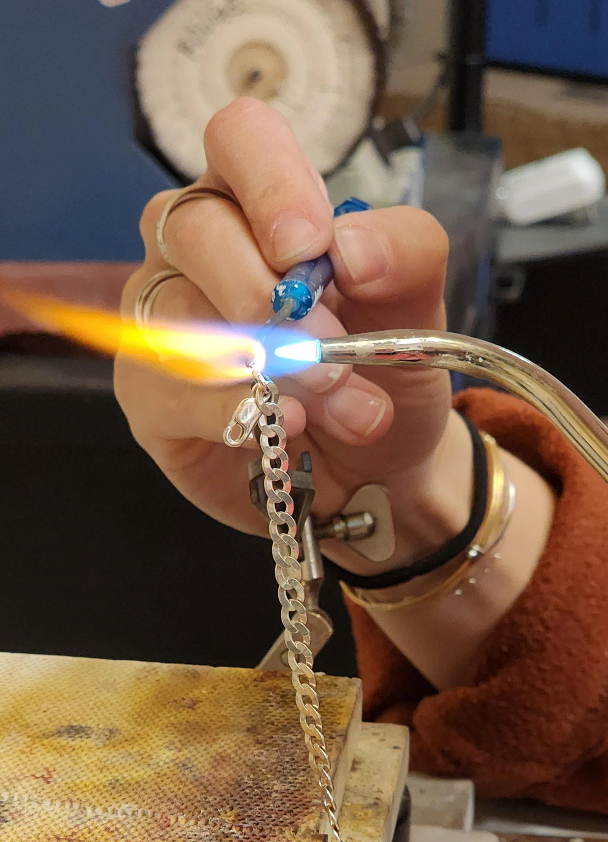 torch and solder pick soldering a lobster clasp to a chain