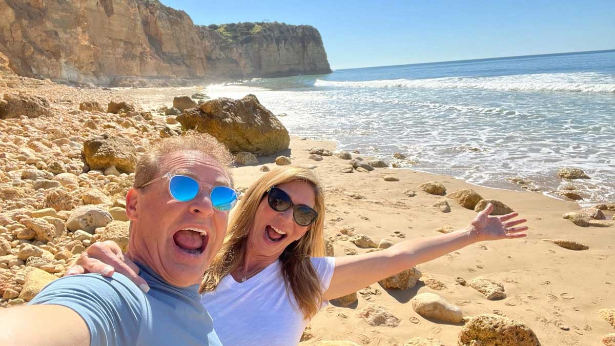 Strategic Coach Member Mike Koenigs with his wife on a rocky beachside