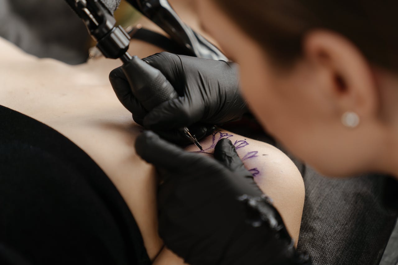 tattoo artist making tattoo on client