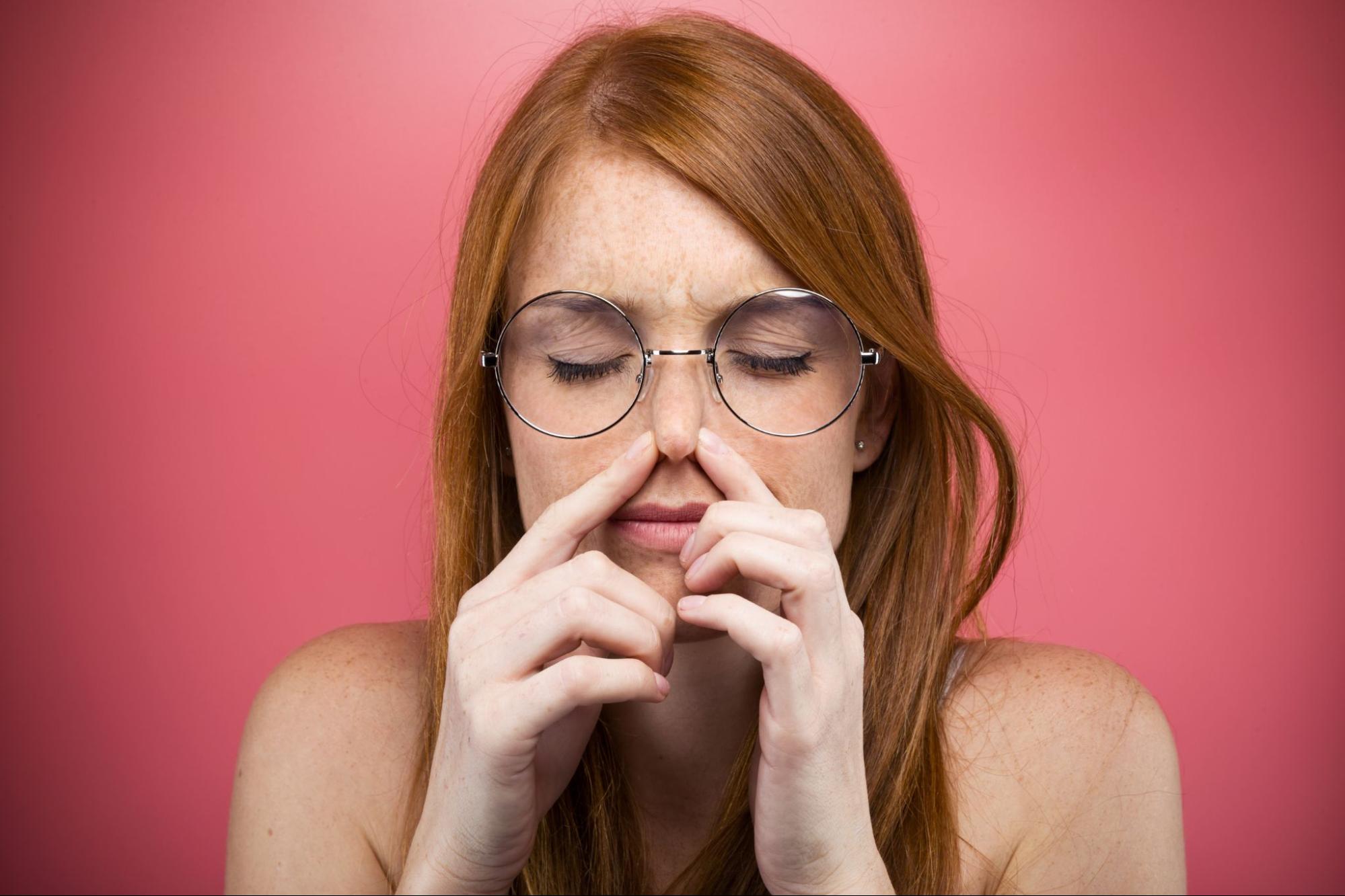 ear popping: woman pinching her nose