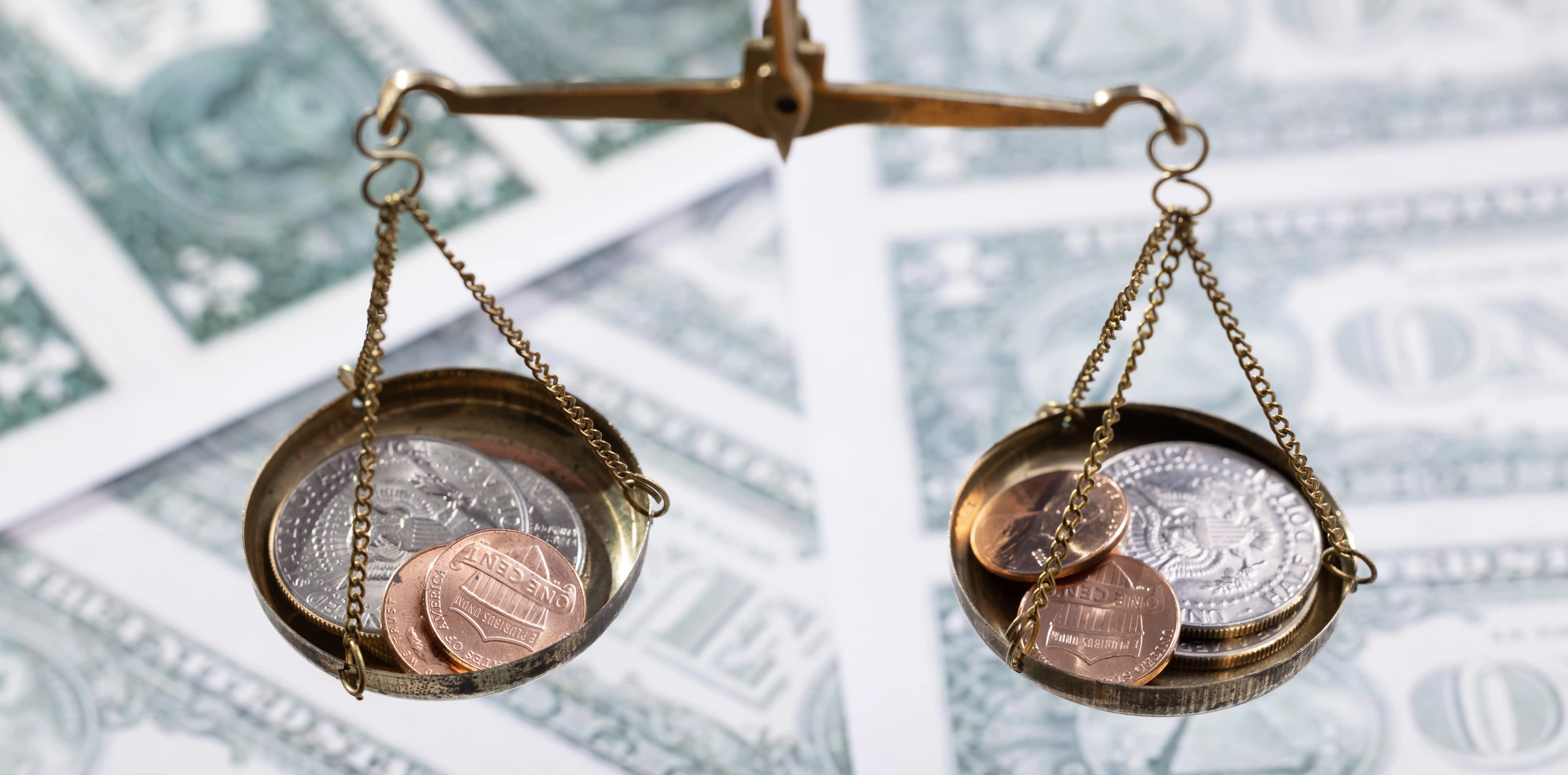 Gold balance scales with coins representing financial transparency and compliance