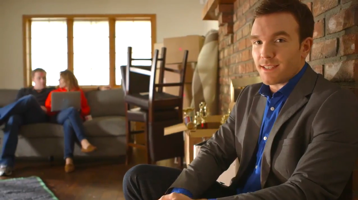 Couple sitting in chair and man sitting next fireplace in living room
