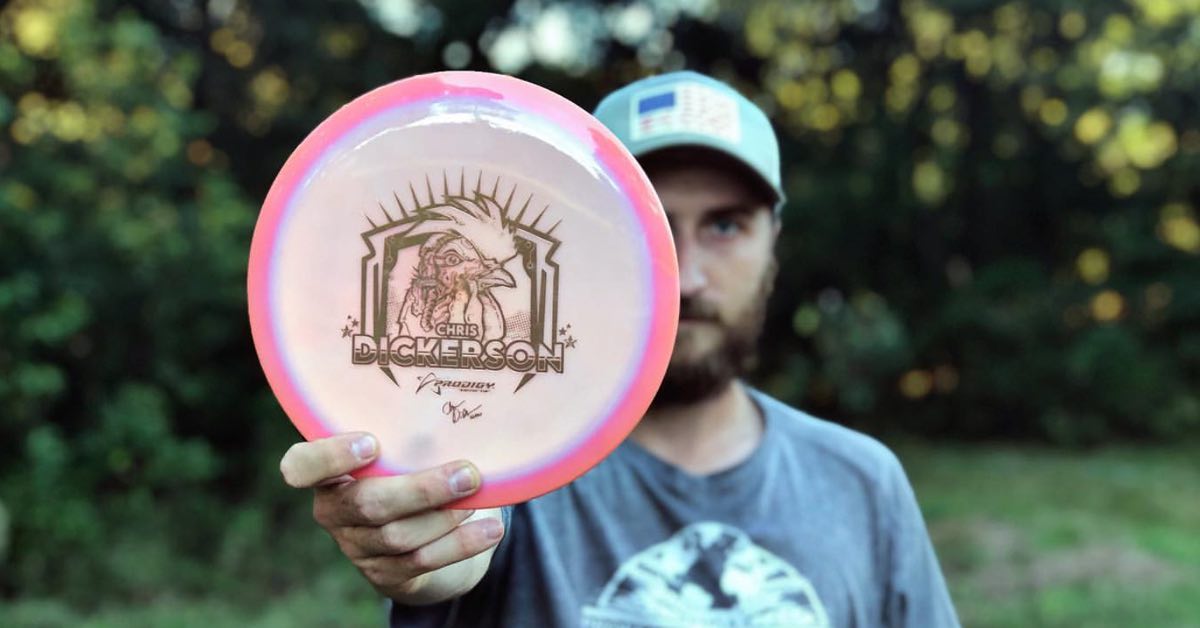 Chris Dickerson holds a pink disc stamped with a chicken head with robotic parts