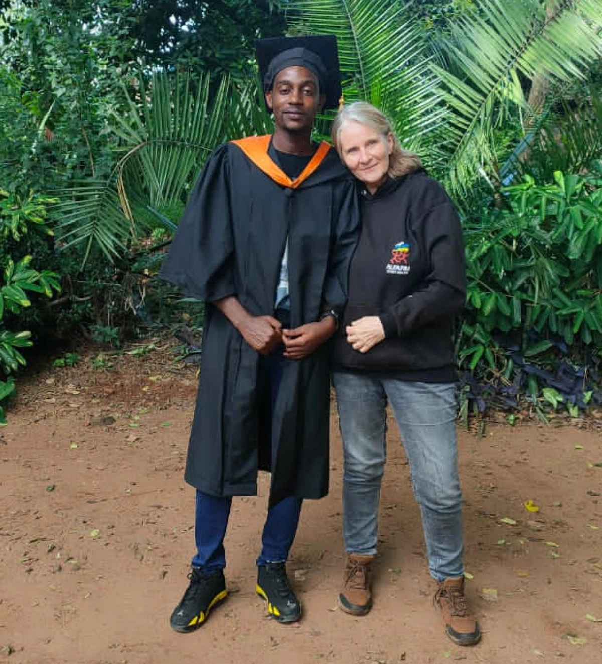 Photograph of Joshua, Pathways student, with woman in Kenya