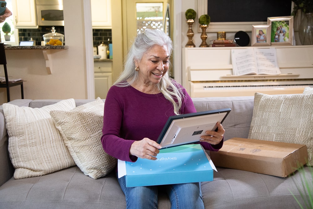 Grandmother excited to open box with Skylight Frame