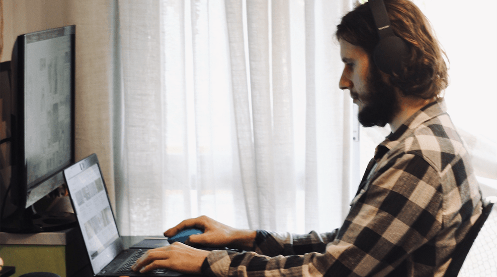 Man working on laptop with headphones on