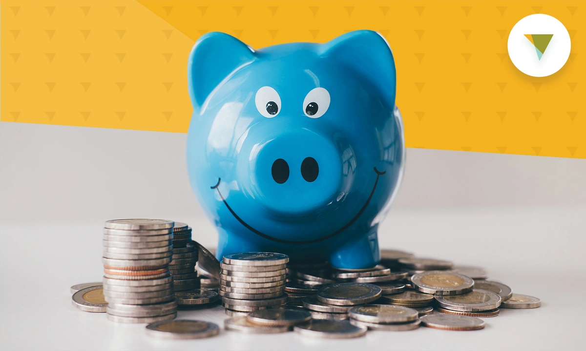 Smiling piggy bank in front of a pile of coins