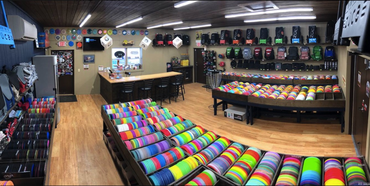 A store with a lot of multicolored disc golf discs and other disc golf equipment
