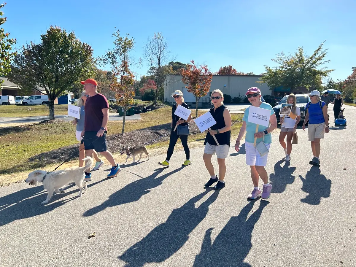 A group of people walk with dogs and holding signs
