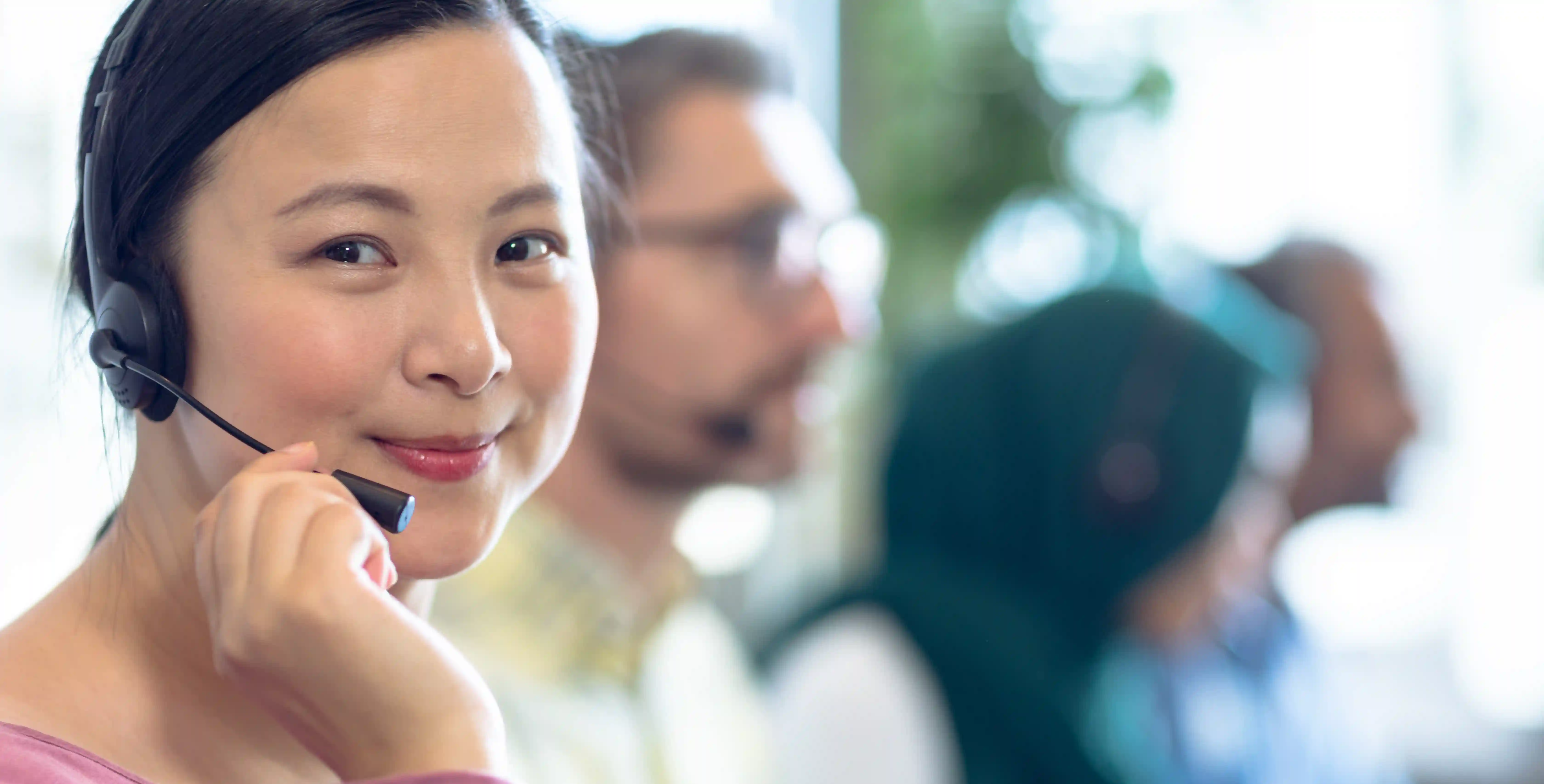 Smiling diverse customer service team representing values-based recruitment in impact-led hiring