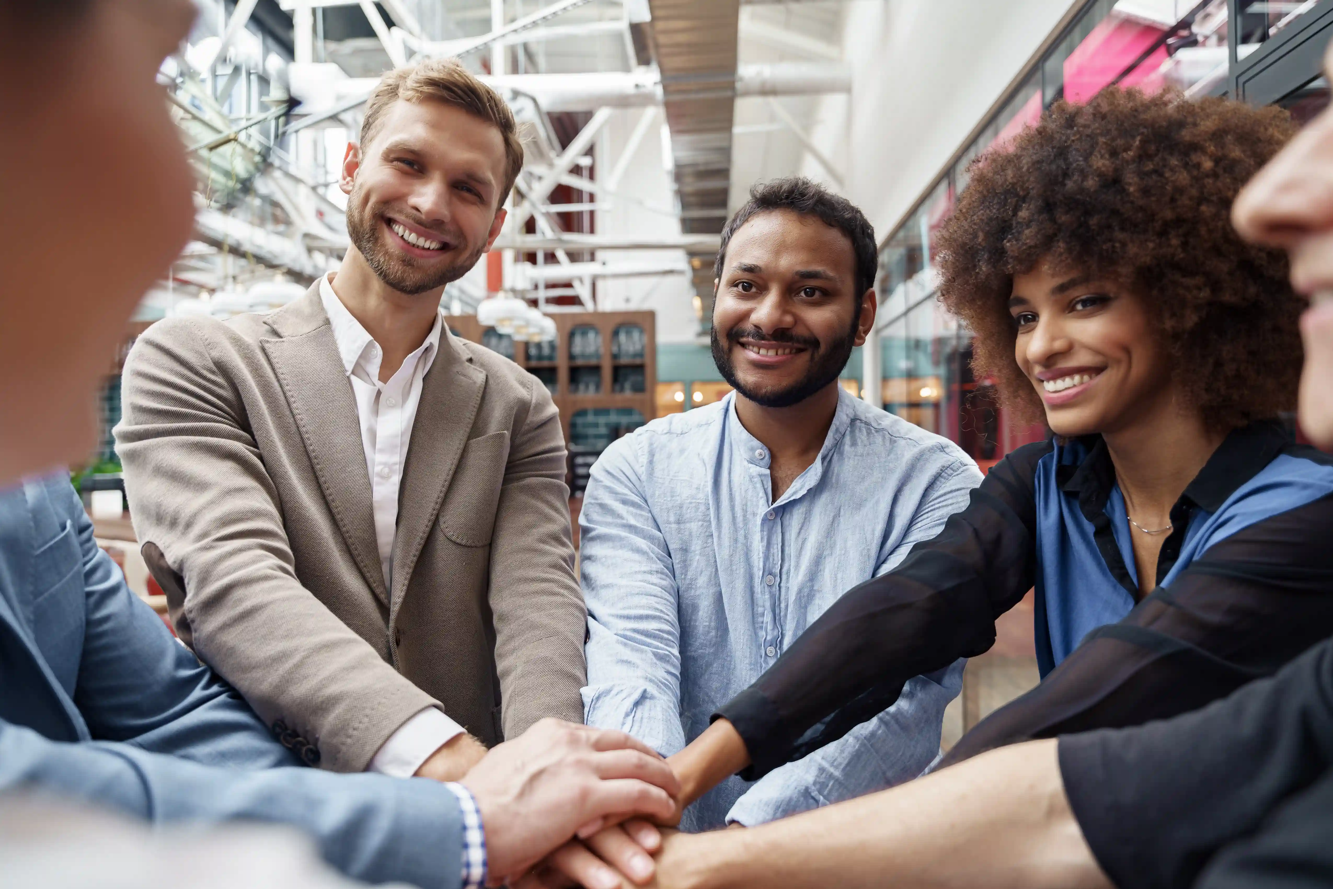 Diverse team stacking hands representing collaboration in scalable business teams