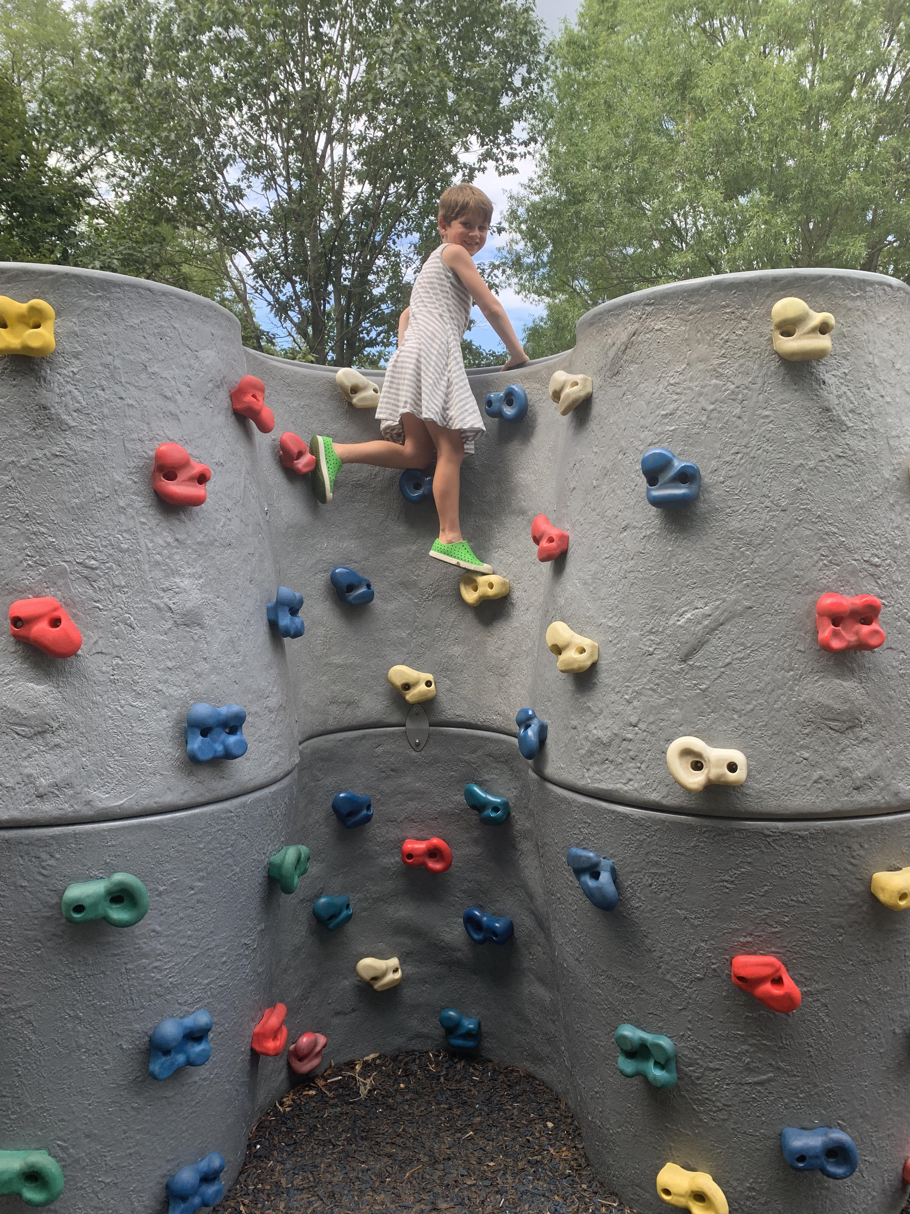 6 year old boy in a gray striped sleeveless dress from Primary rock climbing