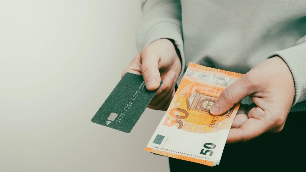 Man holding a credit card and euros.