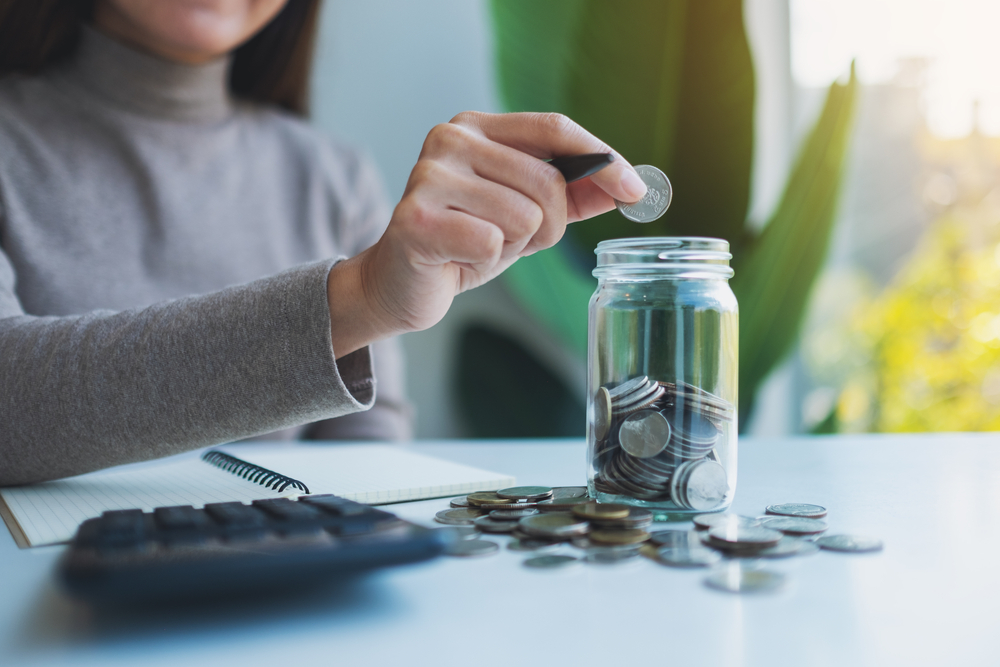 woman putting coins in jar