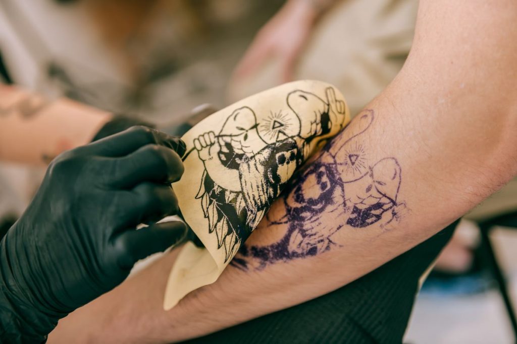 tattooist applying stencil