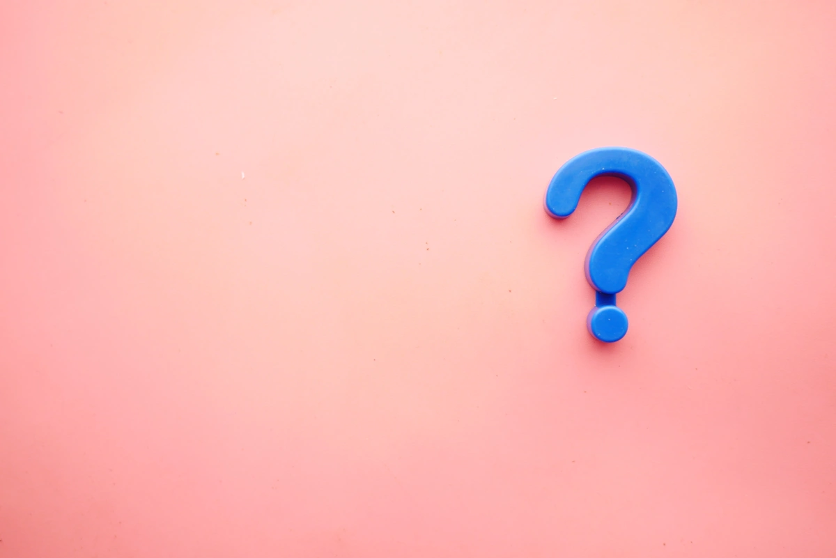 A photo of a blue question mark on a pink background. Learn the best sales follow up questions to ask prospects on the phone.