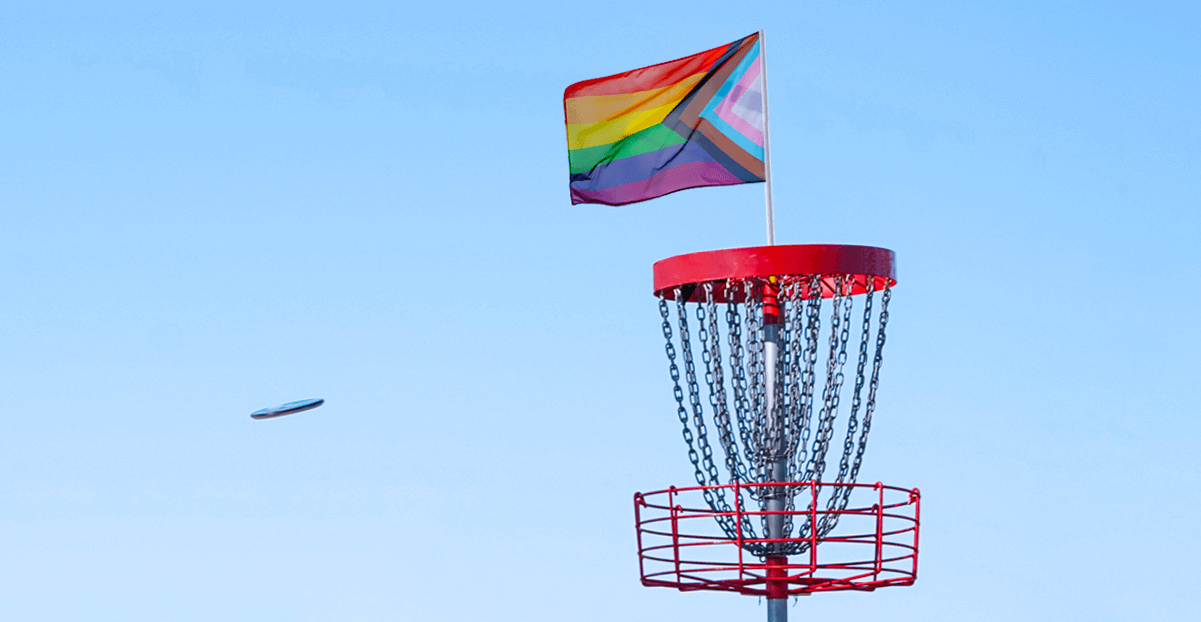 Modern, red disc golf basket with pride flag flying from it