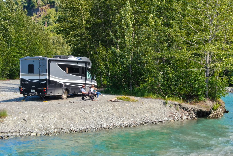 couple outside rv on river