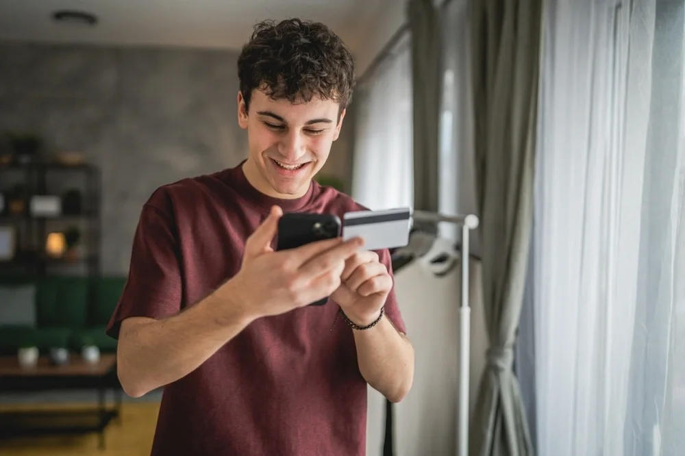 Young man with a credit card in his hand and a mobile phone