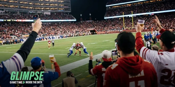 Crowd cheering on football players on a field