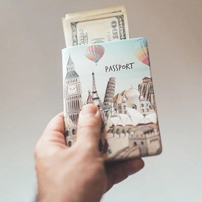 Person holding a passport and cash.