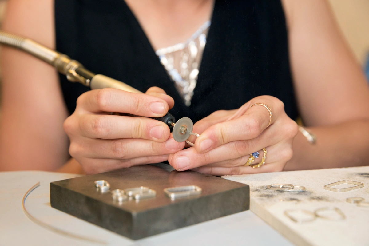 pair of hands using a flex shaft to work on jewelry