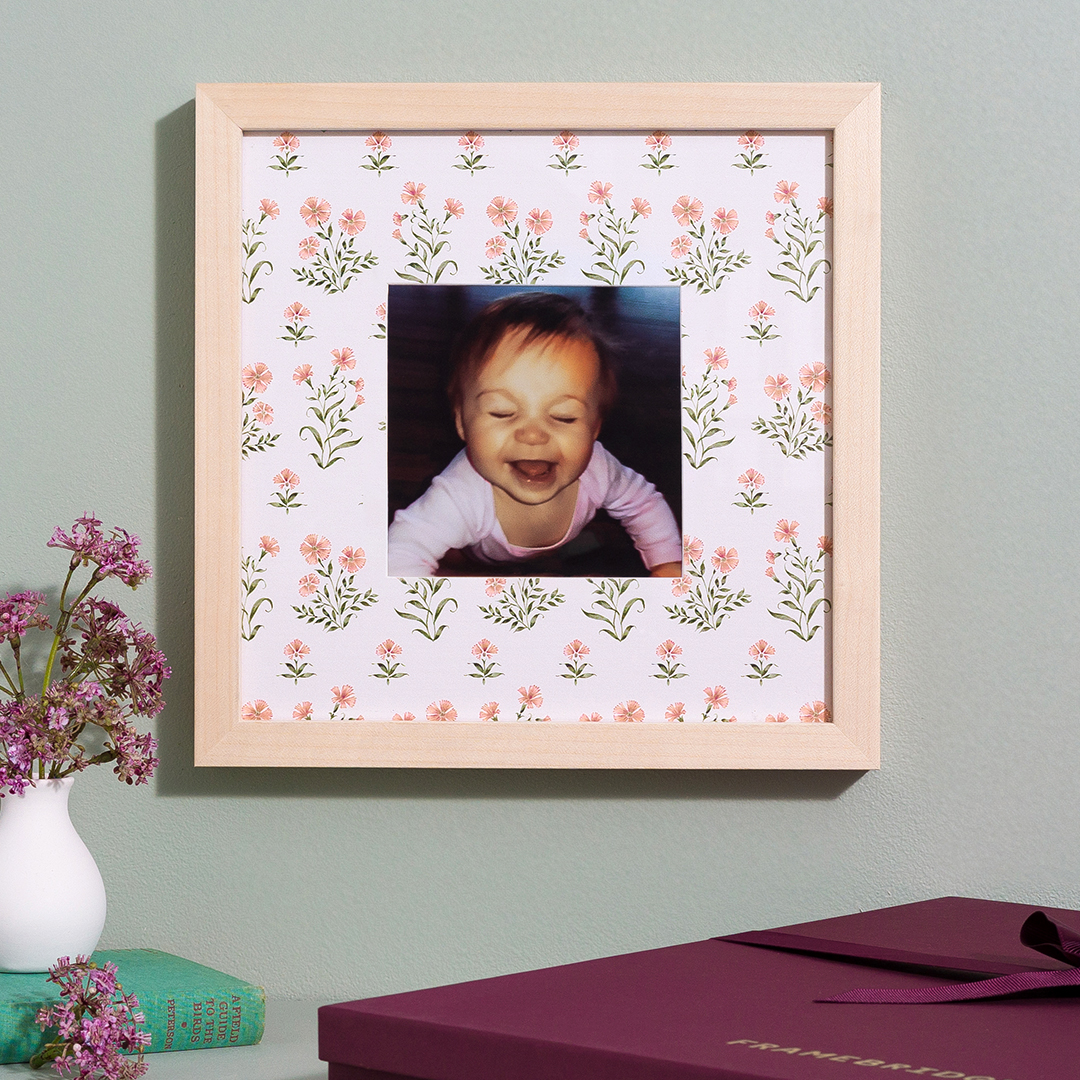 frame with photo of baby and floral mat