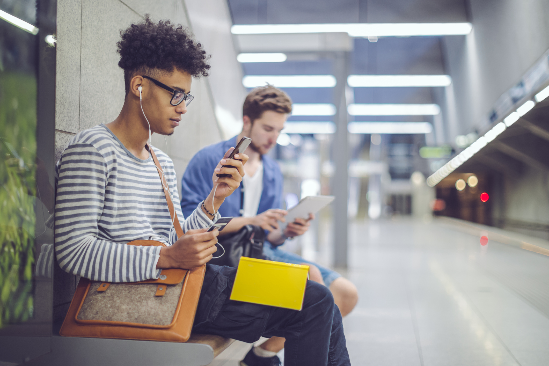 A man looking at his phone while waiting for a train