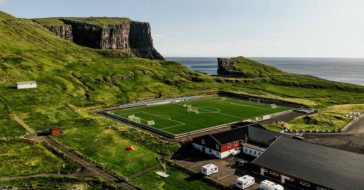 Aerial view of a coastal area with dramatic cliffs with a soccer field