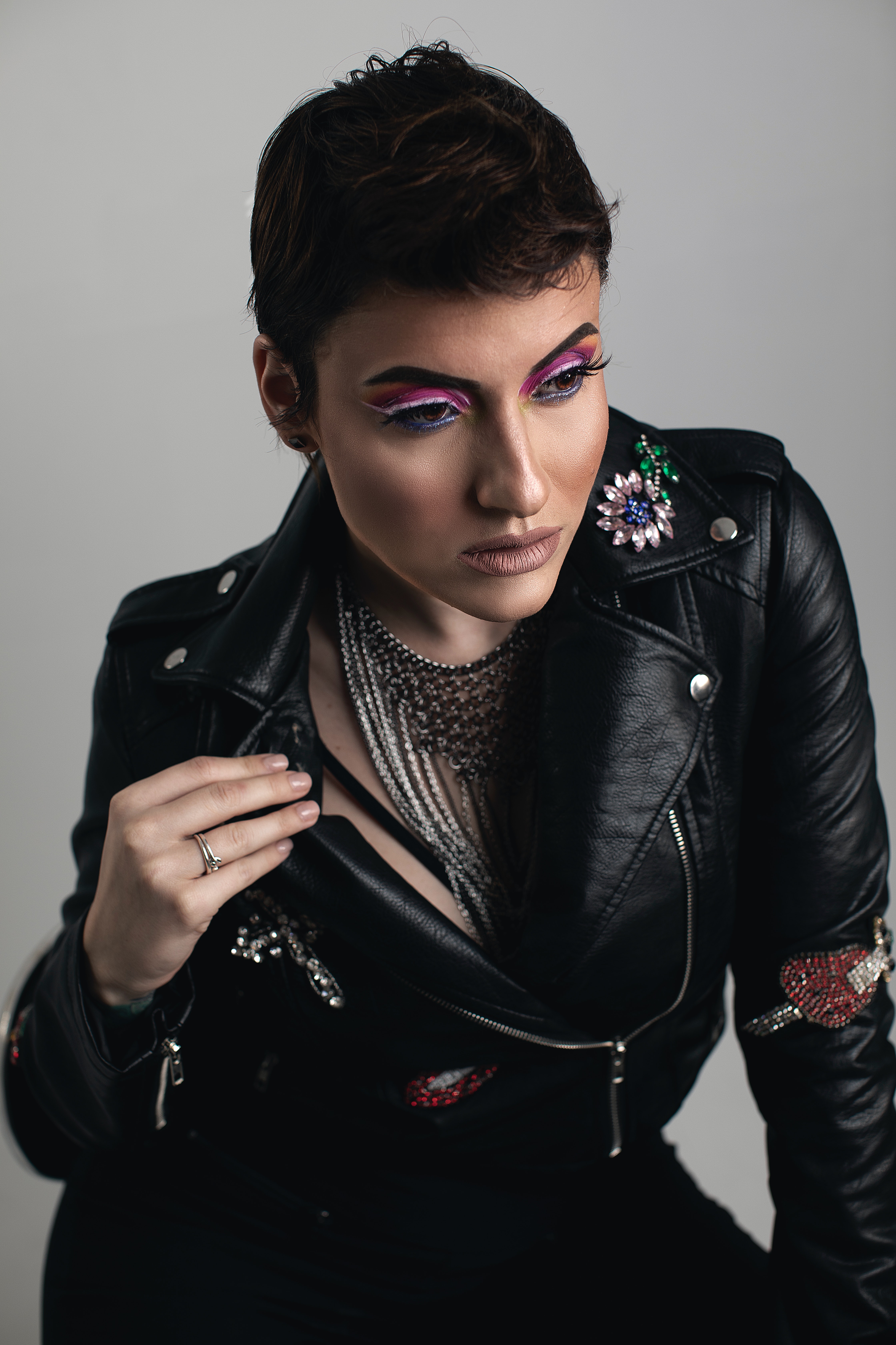 Editorial photo of woman with short dark hair in a leather jacket with a statement necklace