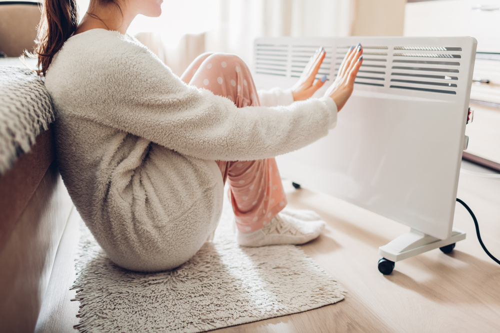 woman warming herself up by radiator