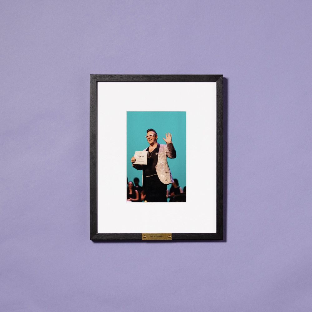framed photo of man accepting award