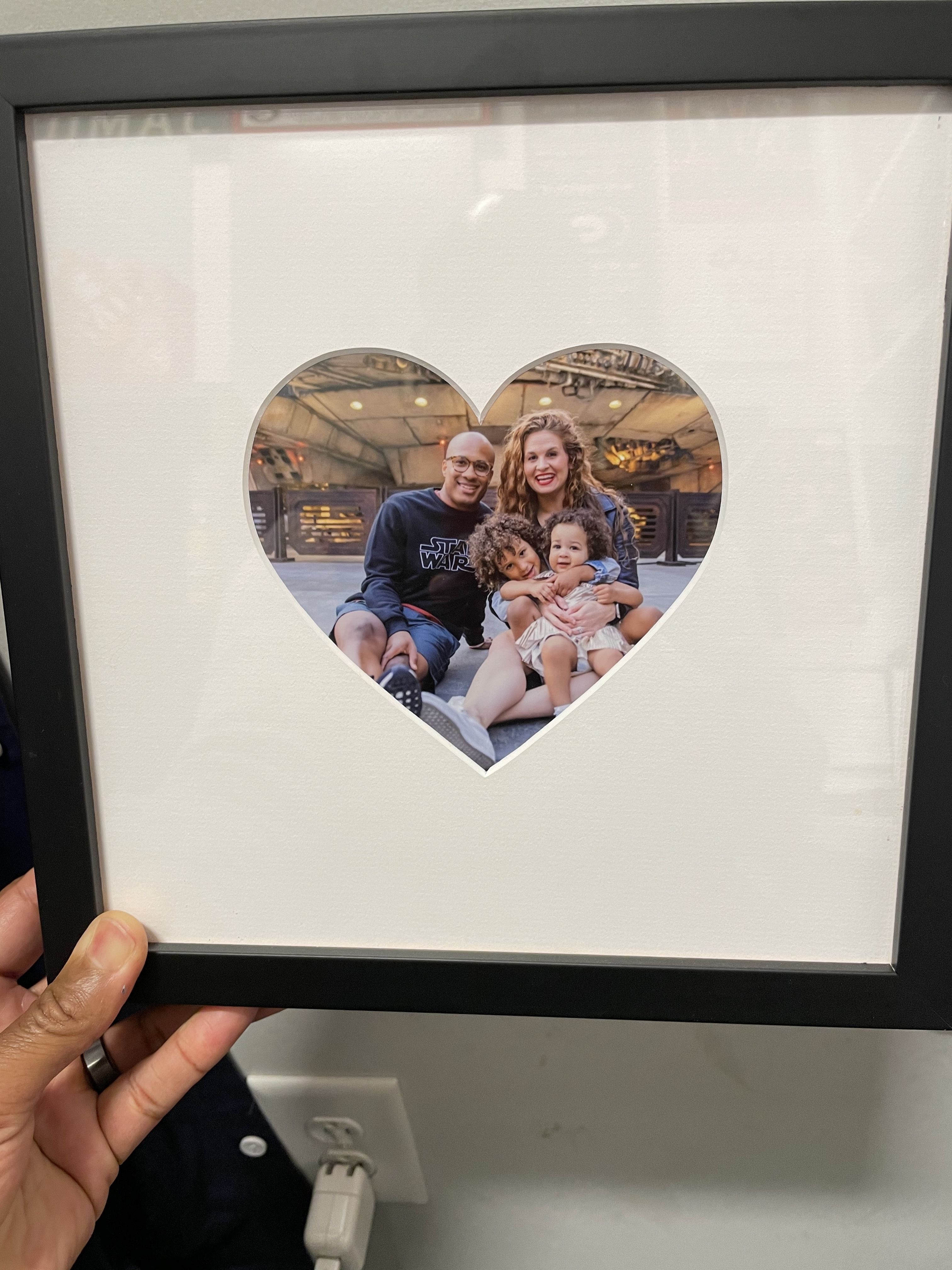 black frame with heart-shaped mat and photo of family