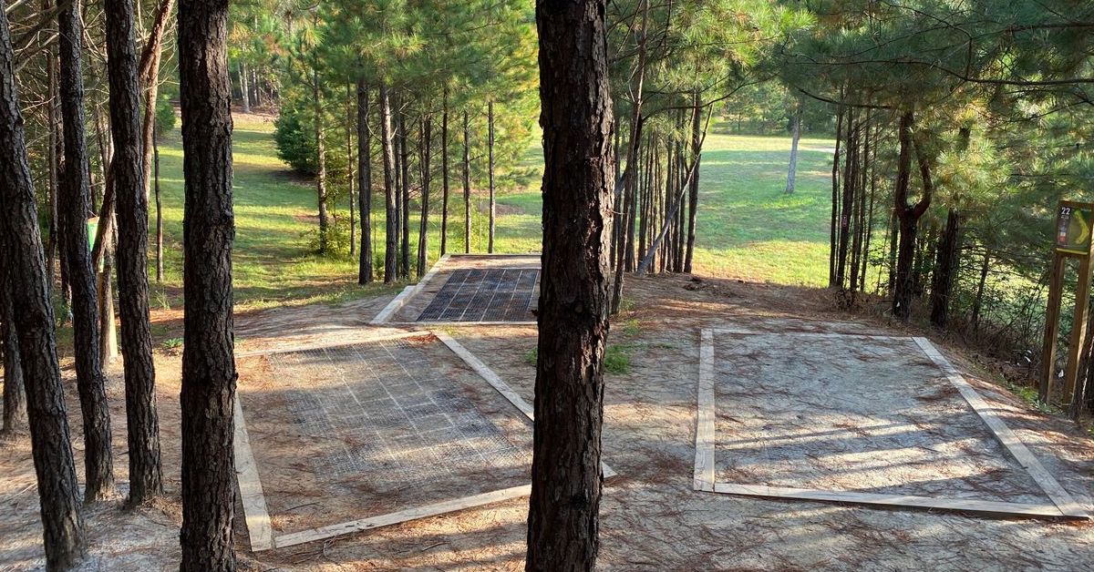 Three disc golf tee pads close together angled to face slightly different directions