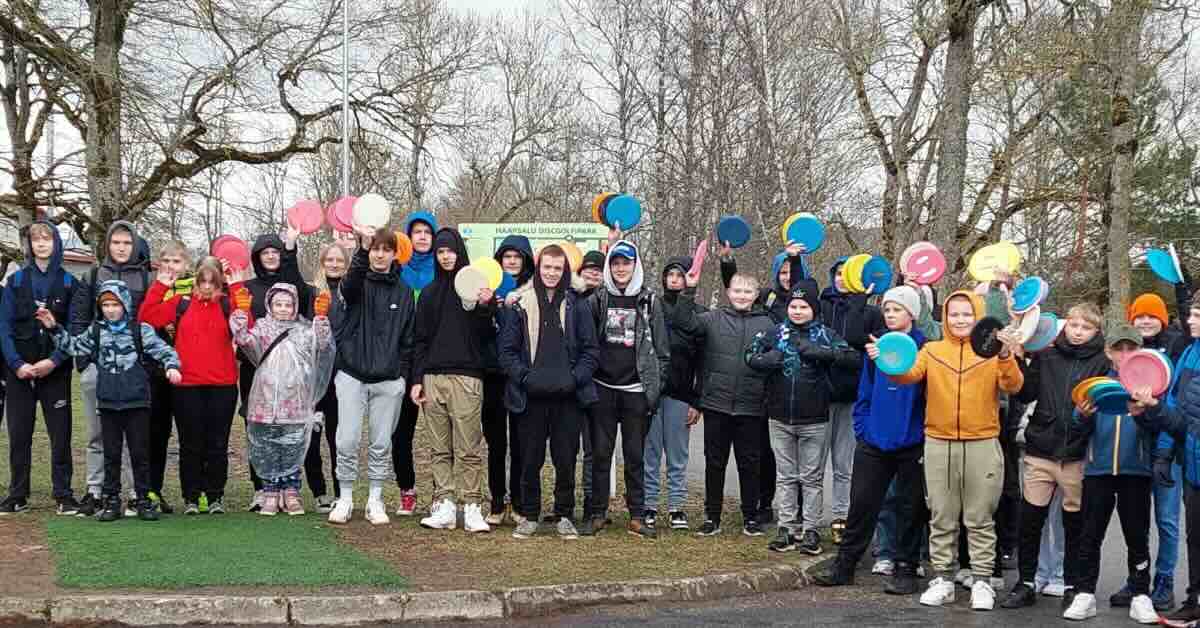 A group of kids pose for a photo holding up discs