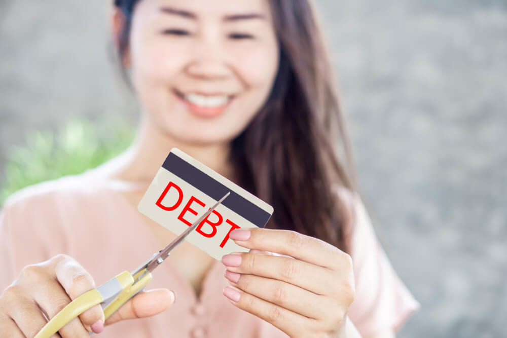 woman cutting card to manage debt