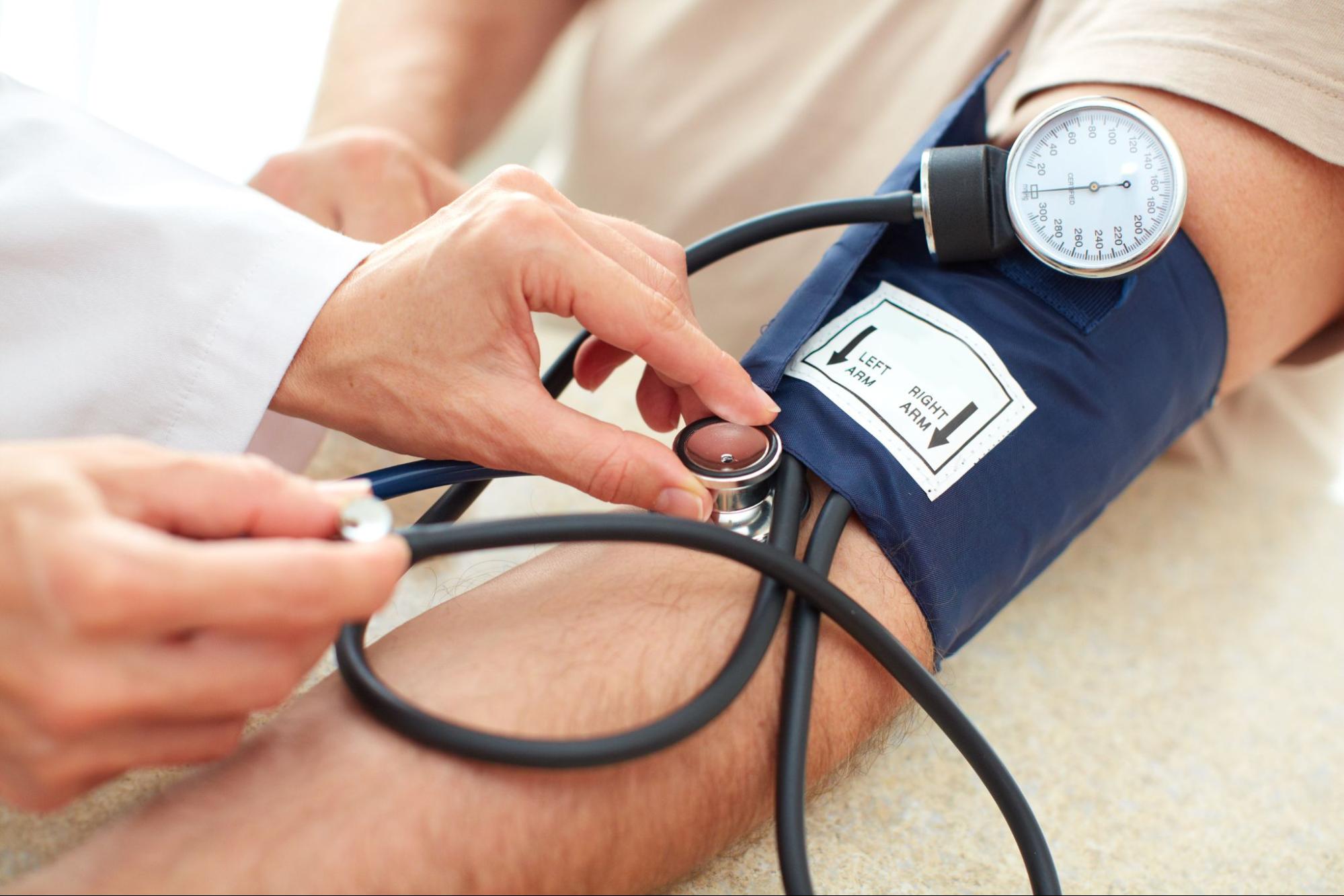 thumping in ear: doctor checking the patients blood pressure