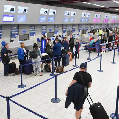 Line of people at an airport check-in kiosk.