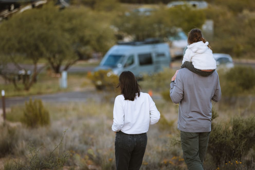 family hiking to their storyteller overland van in arizona