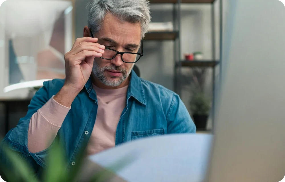Man wearing glasses looking at a report