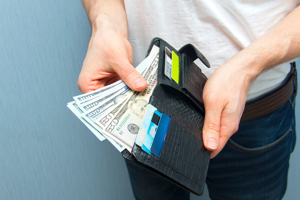 Payday loan cash in man's wallet
