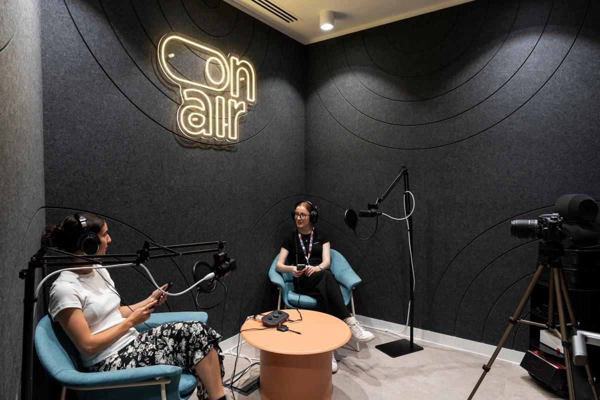 A picture of a small, soundproofed studio space designed for podcasting. The room is equipped with state of the art recording equipment