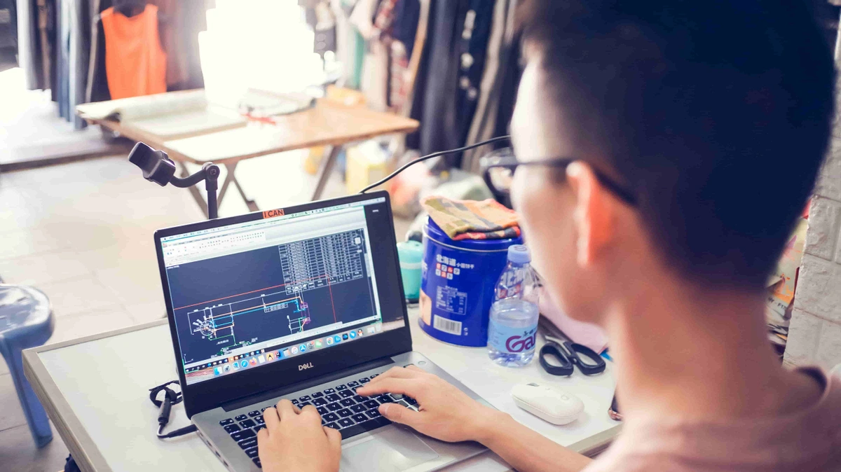 Person working on AutoCAD on a laptop