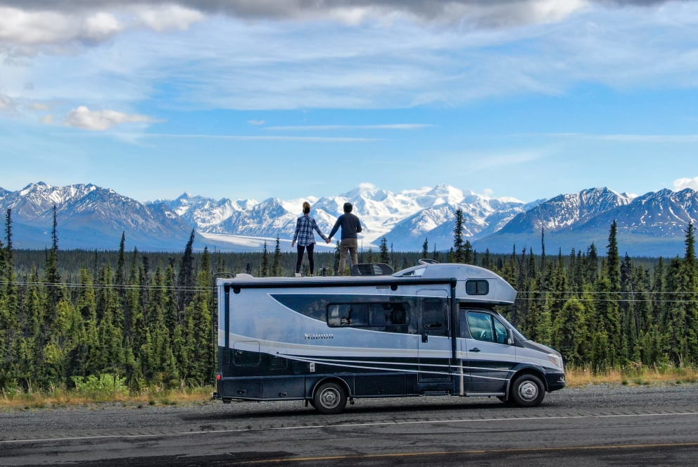 couple ontop of RV in mountains